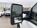A close-up of the side mirror of a 2008 Ford F-250 SD with rain droplets on it