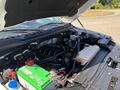 A 2016 Ford F-150 engine compartment with a green battery visible alongside various engine components and a coolant reservoir