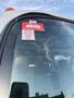 A 2015 Isuzu NPR HD with a certificate of approval sticker on the windshield displaying the months January February March and April