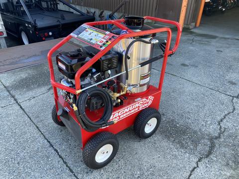 A red Magnum 4000 Hot Water Pressure Washer with a large silver tank and black wheels featuring a control panel and hoses attached