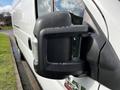 A side view mirror of a 2019 RAM Promaster with a dark casing and an integrated turn signal