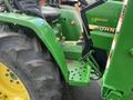 A green 2003 John Deere 790 tractor featuring large rear tires and a visible driver's seat with control levers and a dashboard area