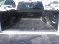 A 2022 Ford F-150 truck bed featuring black liner and Ford logo with a clean and empty interior