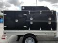 A 2007 Ford F-550 with a black utility body featuring multiple compartments and metal latches on the side for storage and tools