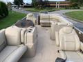 A 2013 Sylvan pontoon boat featuring beige seating with armrests and cup holders designed to accommodate up to thirteen people