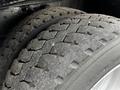 Close-up of two heavily worn tires with a tread pattern featuring grooves and raised edges