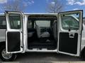 A 2004 Ford Econoline van with its front and side doors open revealing a spacious interior with front seats and a rear bench seat