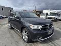 A dark gray 2015 Dodge Durango parked at an outdoor location showcasing its sleek design and chrome accents