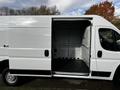 A white 2019 RAM Promaster van with an open side door revealing the empty cargo space inside