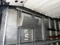 A metallic storage box mounted on a wall inside a vehicle cargo area with visible metal framing and shelves