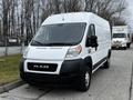 A white 2021 RAM Promaster cargo van with a black front grille and large headlights parked on a road