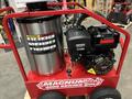 A red Magnum 4000 Hot Water Pressure Washer with a stainless steel tank and a black engine mounted on a wheeled frame designed for heavy-duty cleaning tasks