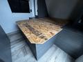 A wooden table made of oriented strand board is positioned in the foreground with a smooth edge and a light wood grain finish
