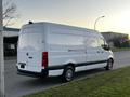 A white 2019 Mercedes-Benz Sprinter van parked with a high roof and sliding side door featuring black accents on the lower body and alloy wheels