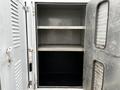 An empty metal storage compartment with two shelves in a 2006 GMC C5000 vehicle