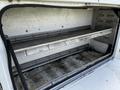 Interior view of a 2008 Ford F-550 truck bed with metal shelves and storage compartments visible