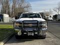 A white 2017 Chevrolet Silverado 3500HD with a black grille guard and mounted lights visible in the front