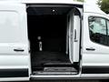 A 2022 Ford Transit with an open sliding door revealing its interior cargo space featuring a clean black floor and walls