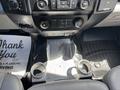 The interior of a 2016 Ford F-150 featuring a center console with two cup holders and climate control buttons