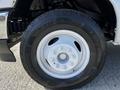 A close-up view of a white wheel with a silver rim and tire labeled with the brand name and model number