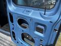 A blue 2008 Ford E-350 van door shell with cutouts for a window and locks but no glass or handles installed