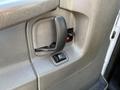 Close-up of the interior door handle and window control switch of a 2014 Chevrolet Express
