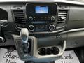 Dashboard of a 2022 Ford Transit featuring a central display screen radio controls air conditioning knobs and gear shift lever