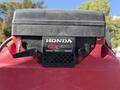 Close-up of a Honda GX670 V-Twin engine with a black cover and red body, featuring controls and ventilation grilles