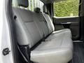 The interior of a 2017 Ford F-250 SD featuring a gray cloth bench seat with three seating positions and a seatbelt on the right