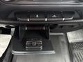 Dashboard control panel of a 2016 GMC Sierra 1500 featuring buttons for various functions and a small compartment below