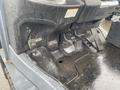 A 2011 Toyota 028FG15 forklift with visible foot pedals and controls in the operator compartment showing signs of wear and rainwater.