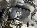 A close-up view of a component from a 2010 Freightliner M2 106 engine featuring a black valve with a key insert and surrounding hoses and wiring