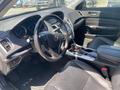 Interior view of a 2017 Acura TLX featuring a steering wheel dashboard and center console with gear shift and cup holders