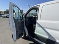 A 2016 Ford Transit van with the front driver's side door open revealing the interior cabin and dashboard