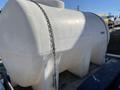 A large white plastic tank on a trailer with a chain attached to it