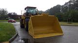 A 2019 Caterpillar 972M XE wheel loader with a large yellow bucket positioned in front, displaying heavy-duty construction equipment design