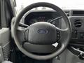 A close-up of the steering wheel of a 2009 Ford Econoline featuring the Ford logo and control buttons on the wheel