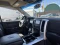 Interior view of a 2011 RAM 1500 showing the dashboard center console and driver seat with controls and storage compartments