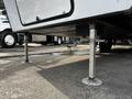 A 2021 Grand Design Recreational 311BHS travel trailer positioned on stabilizing jacks with visible support legs on a parking surface