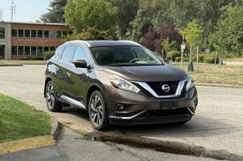 A 2016 Nissan Murano in brown parked with its front angled towards the viewer showcasing its sleek design and distinctive headlights