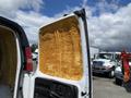 A 2009 Chevrolet Express van with an open side door revealing exposed orange insulation material inside the door frame