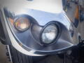 Close-up of the front of a 2016 International WorkStar 7500 with shiny chrome detailing and two headlights illuminated