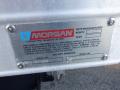 A metal identification plate on a 2014 International Durastar truck displaying the manufacturer's name and vehicle information