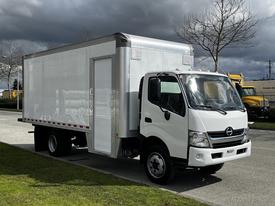 A white 2018 Hino 195 box truck parked with a closed rear door and a side door visible on the cargo area