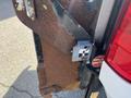 Close-up of a rusty metal section attached to a 2013 Ford F-250 SD with a visible lock mechanism and a label featuring a graphic symbol