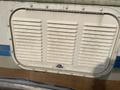 A Dometic RM2351 refrigerator vent cover with horizontal slats mounted on a 1987 Chevrolet Fleetwood Pace Arrow motorhome exterior