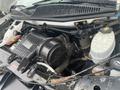 A close-up view of the engine compartment of a 2012 Chevrolet Express showing various components including the air intake and fluid reservoirs