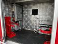 Interior of a 2009 Spartan Gladiator showcasing metal surfaces with red straps and fixtures for securing equipment or passengers