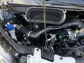 A close-up view of the engine compartment of a 2021 Ford Transit showcasing the intake manifold air filter and various hoses and components
