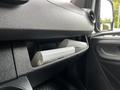 The interior dashboard of a 2019 Mercedes-Benz Sprinter showing a glove compartment with two white boxes neatly stored inside